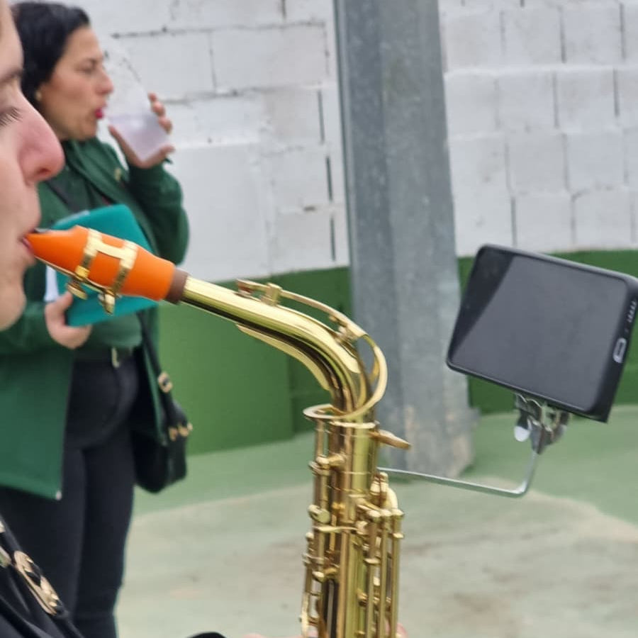 Atril magnético Braggs3D usandose en una actuación en un saxofón para leer partituras en móvil